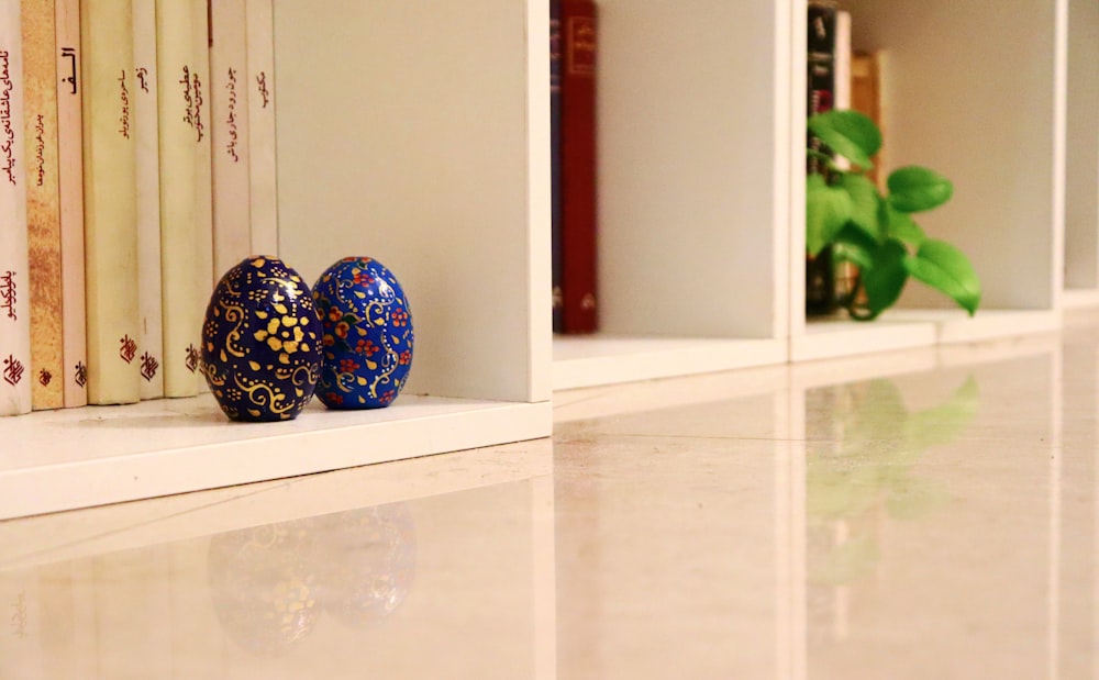 blue and white floral egg ornament on white wooden cabinet