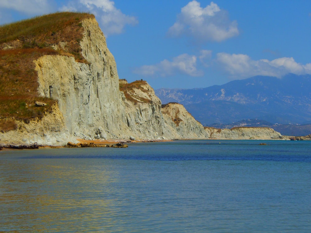 brown rock formation on sea under blue sky during daytime