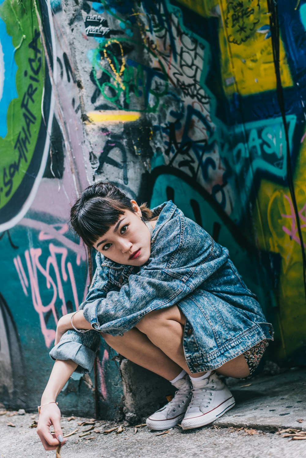 girl in purple dress sitting on concrete wall