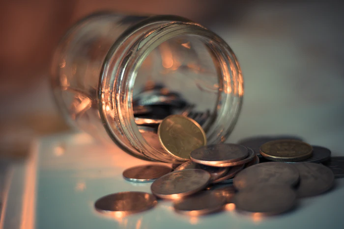 A clear glass jar with coins
