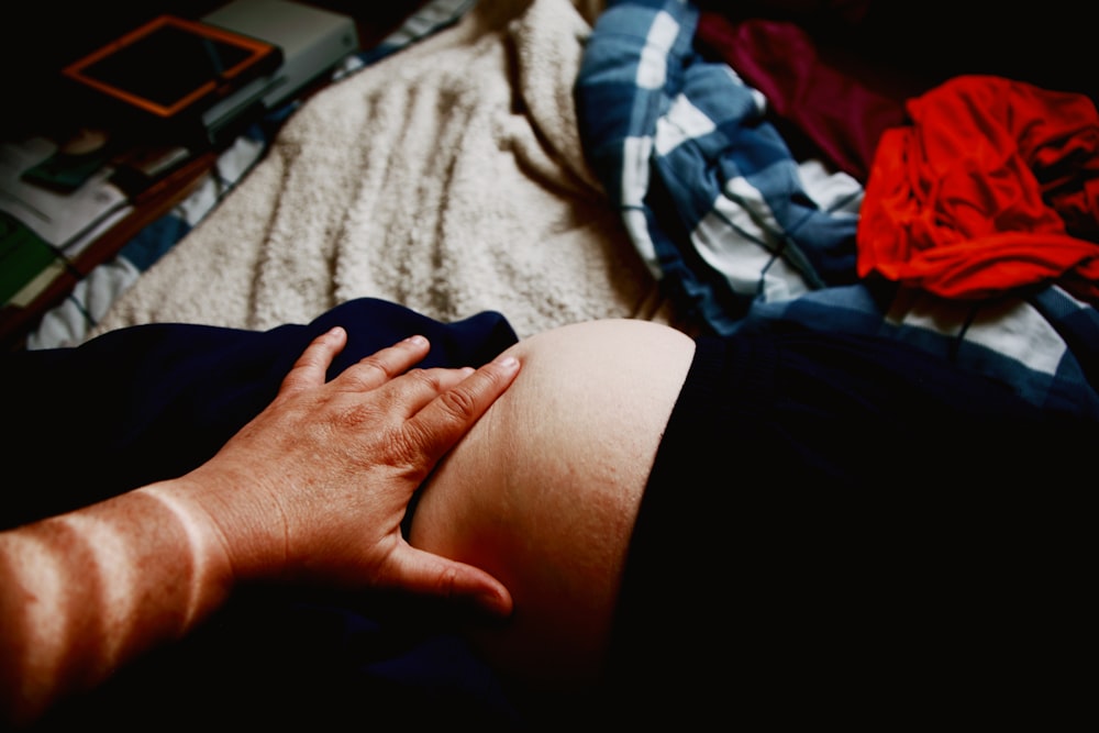 person in black shorts lying on bed