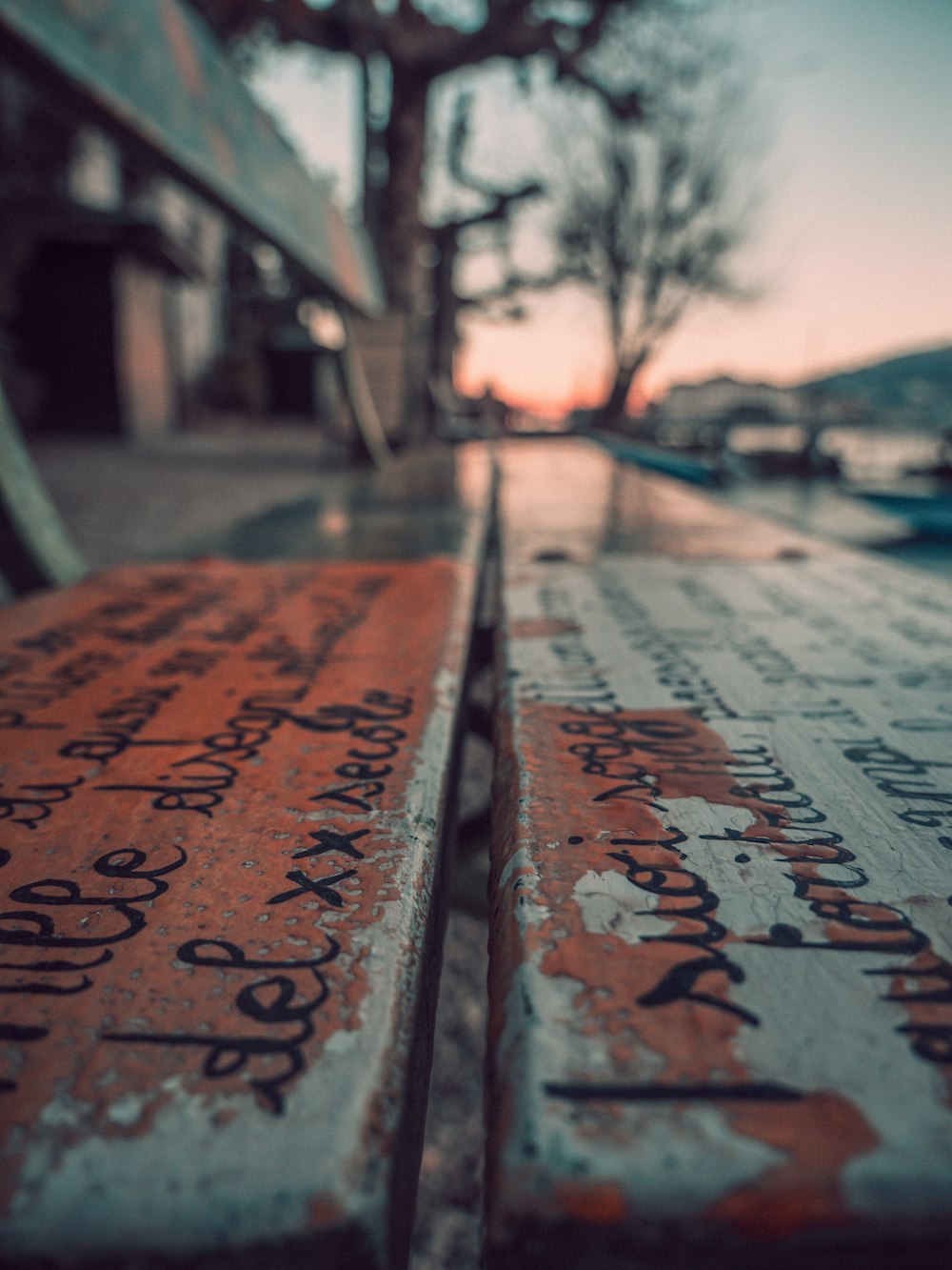 a close up of a wooden bench with writing on it