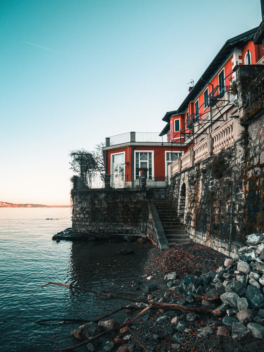 red and white concrete building beside body of water during daytime