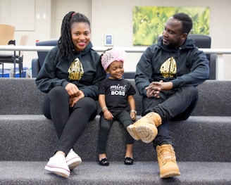 man in black hoodie sitting beside woman in black and yellow long sleeve shirt