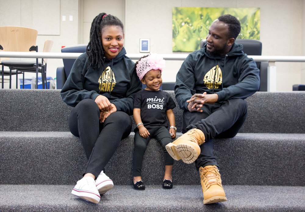 man in black hoodie sitting beside woman in black and yellow long sleeve shirt