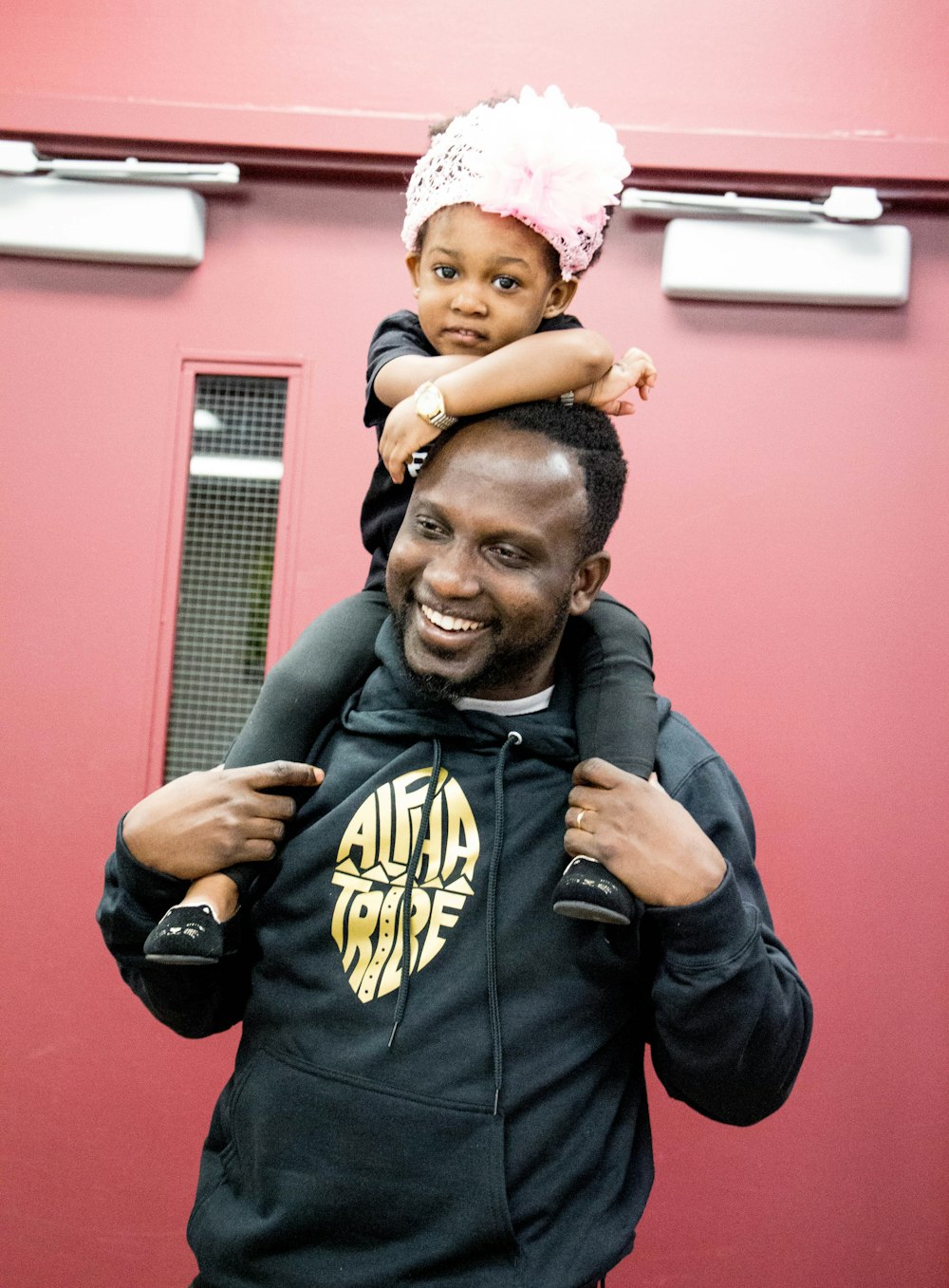 man in black and yellow batman hoodie carrying baby in black and yellow batman hoodie