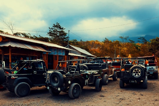 black and gray single cab pickup truck parked near brown wooden house during daytime in Mount Merapi Indonesia