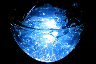Close-up of a scientist holding a vial with a glowing blue liquid in a modern lab
