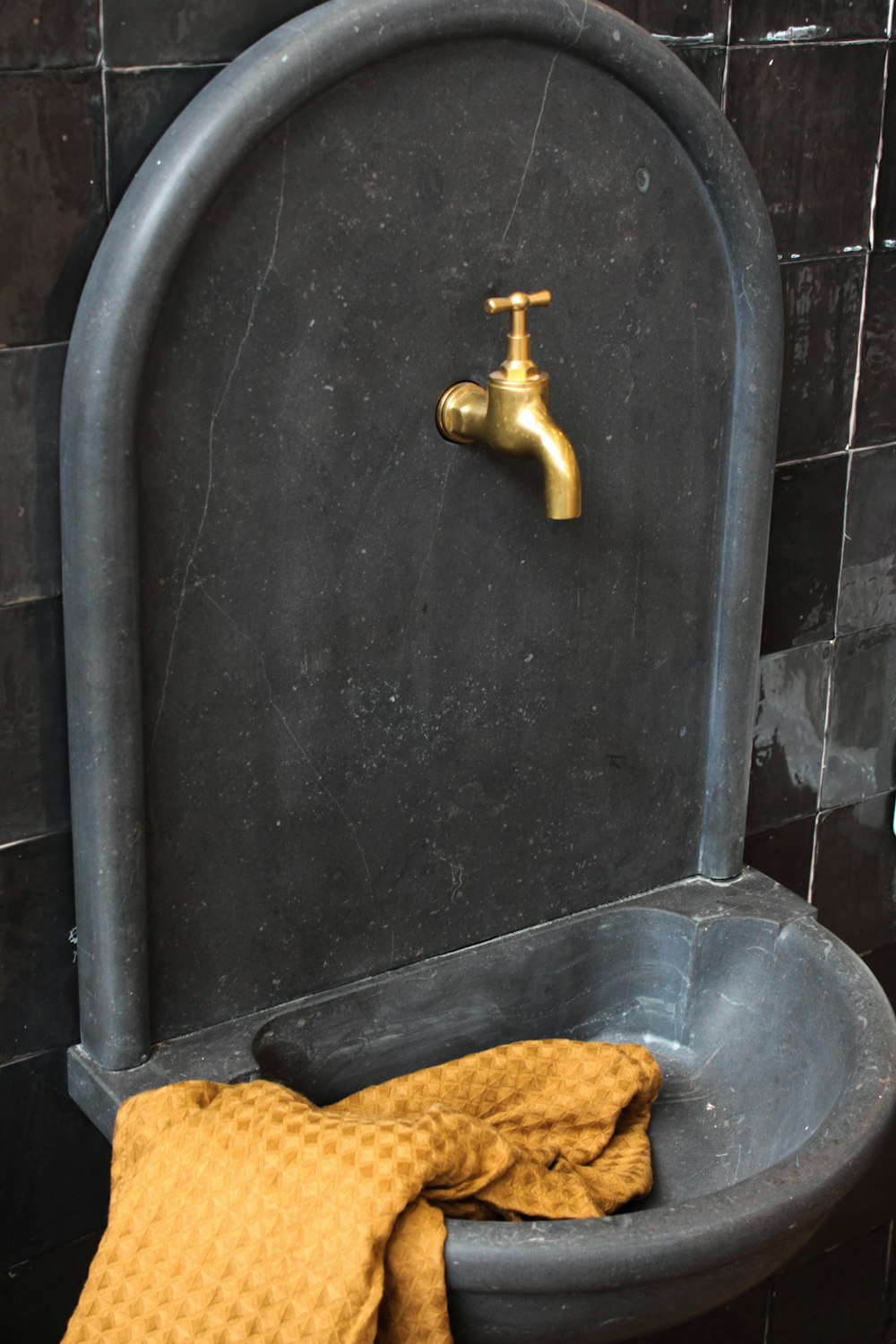 yellow and brown faucet on black ceramic sink