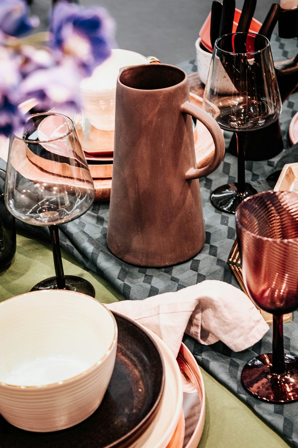 brown ceramic pitcher beside white ceramic mug on table