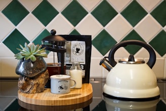 white and black ceramic teapot on brown wooden table