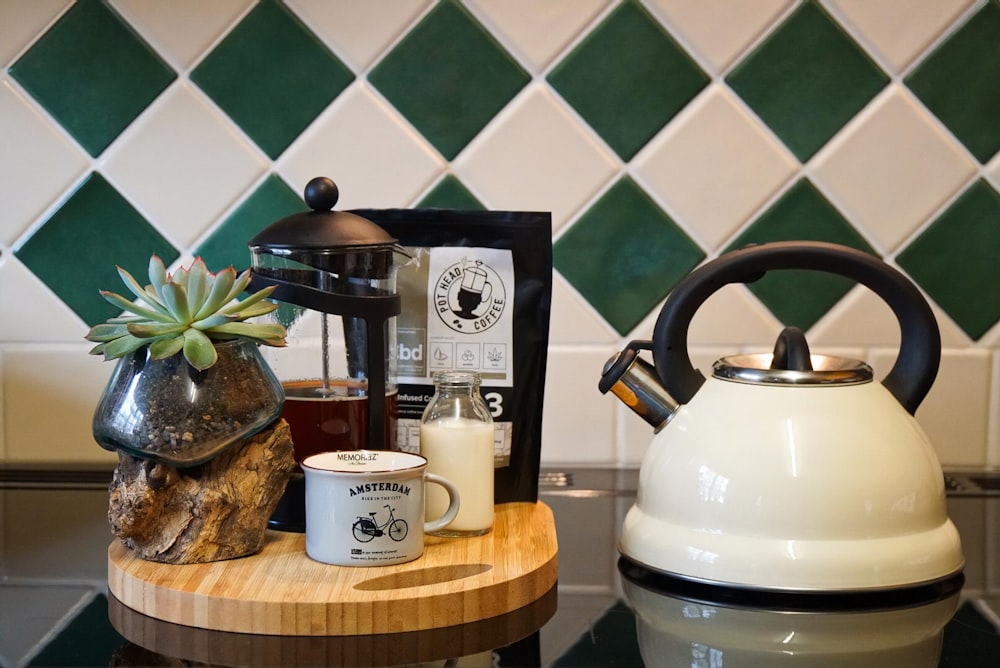 white and black ceramic teapot on brown wooden table