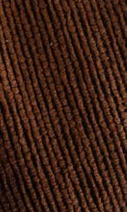 Close-up of a rich corduroy cap in deep burgundy, highlighting its soft texture and meticulous stitching.