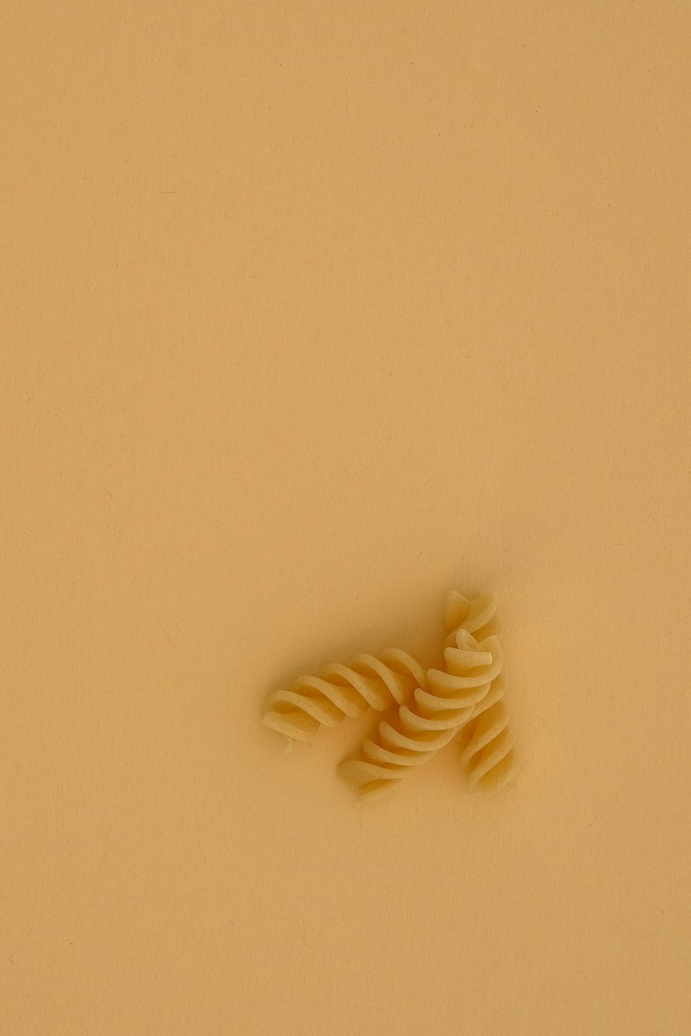 white spiral pasta on white table