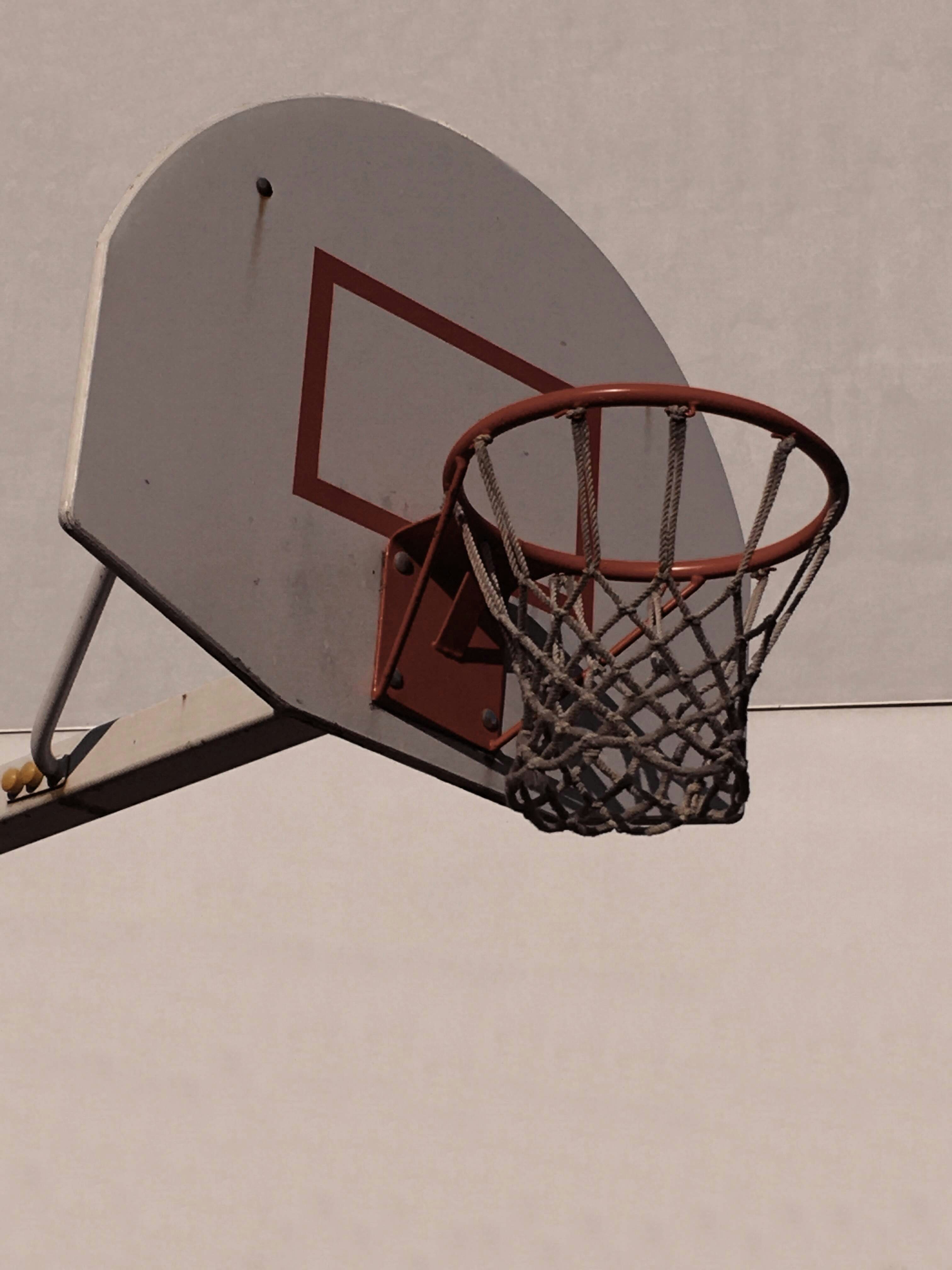 A basketball going through the rim of a basketball hoop photo – Free ...
