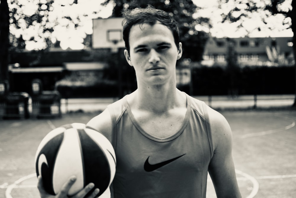 man in tank top holding basketball