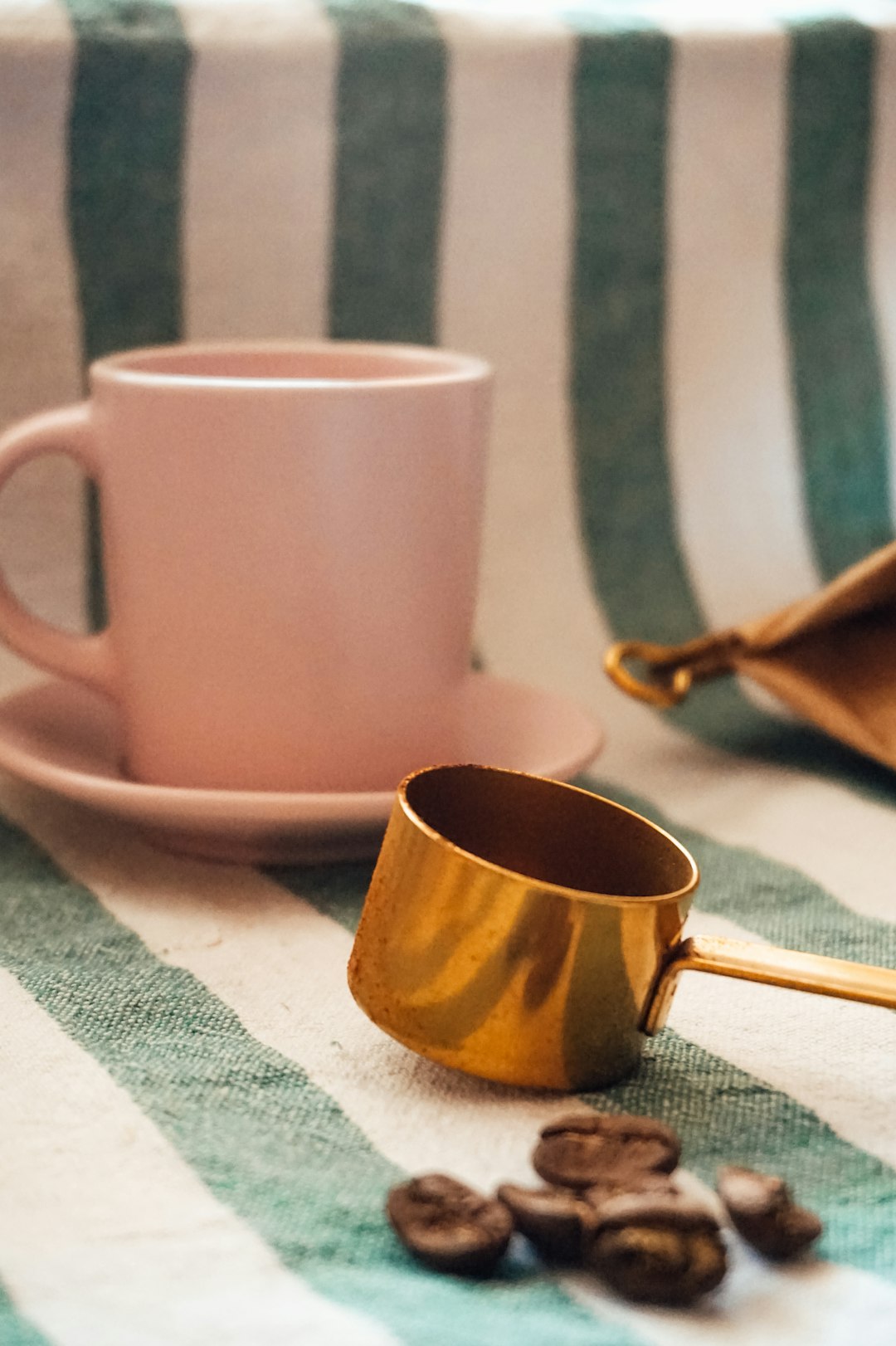 brown ceramic mug on white and green textile
