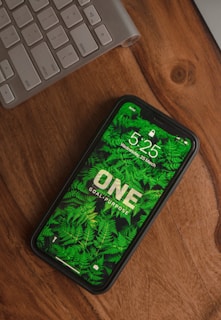 black and green android smartphone on brown wooden table