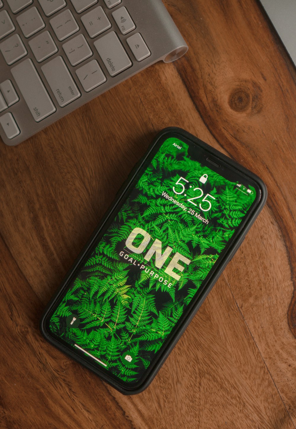 smartphone android preto e verde na mesa de madeira marrom