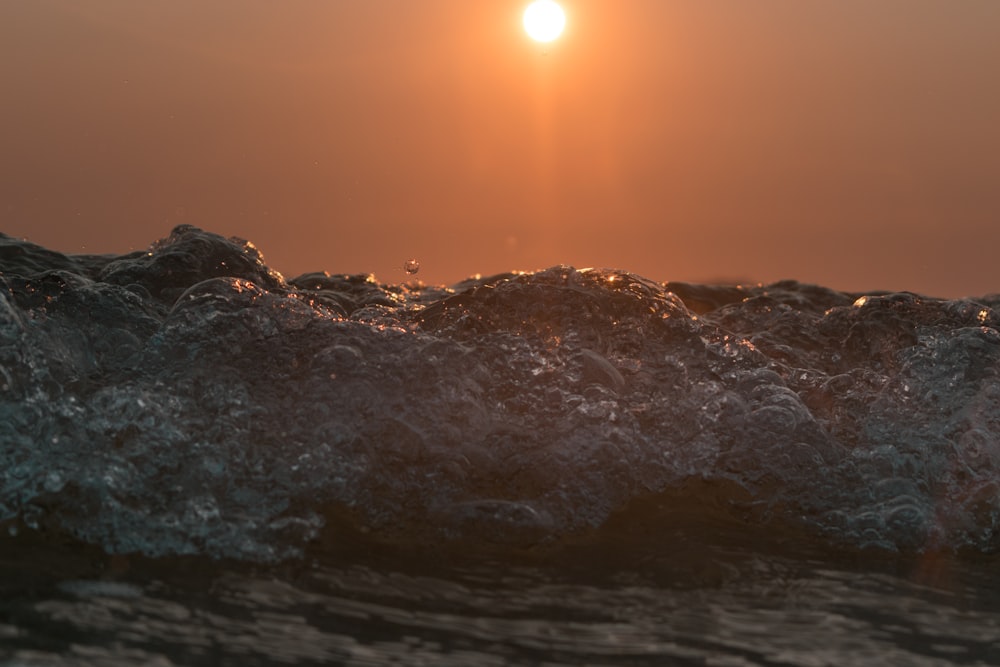 Olas de agua en la costa rocosa durante la puesta del sol