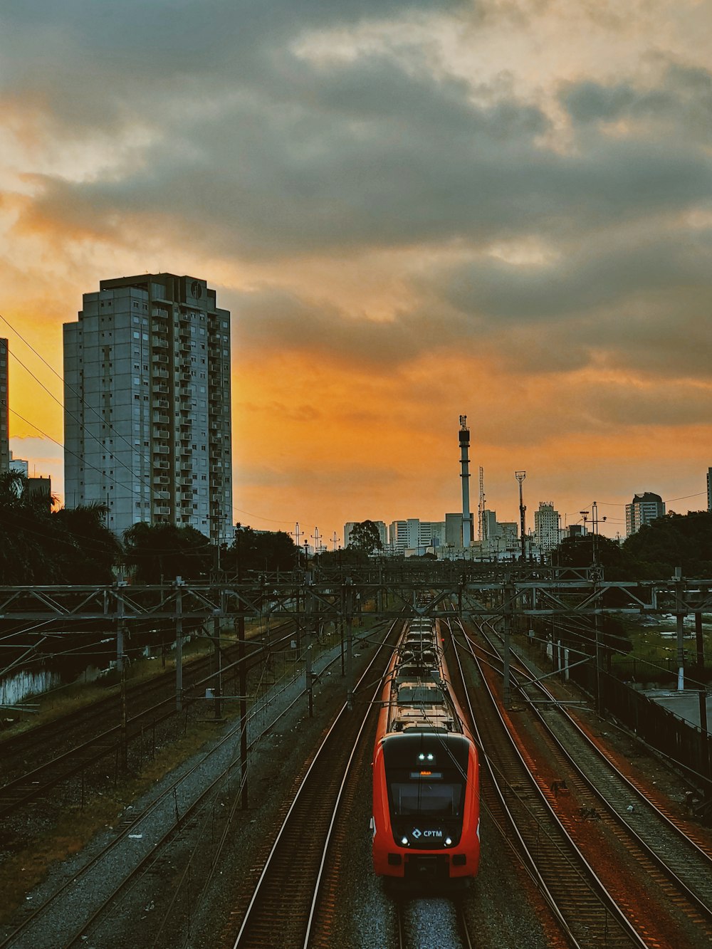 red and black train on rail during sunset