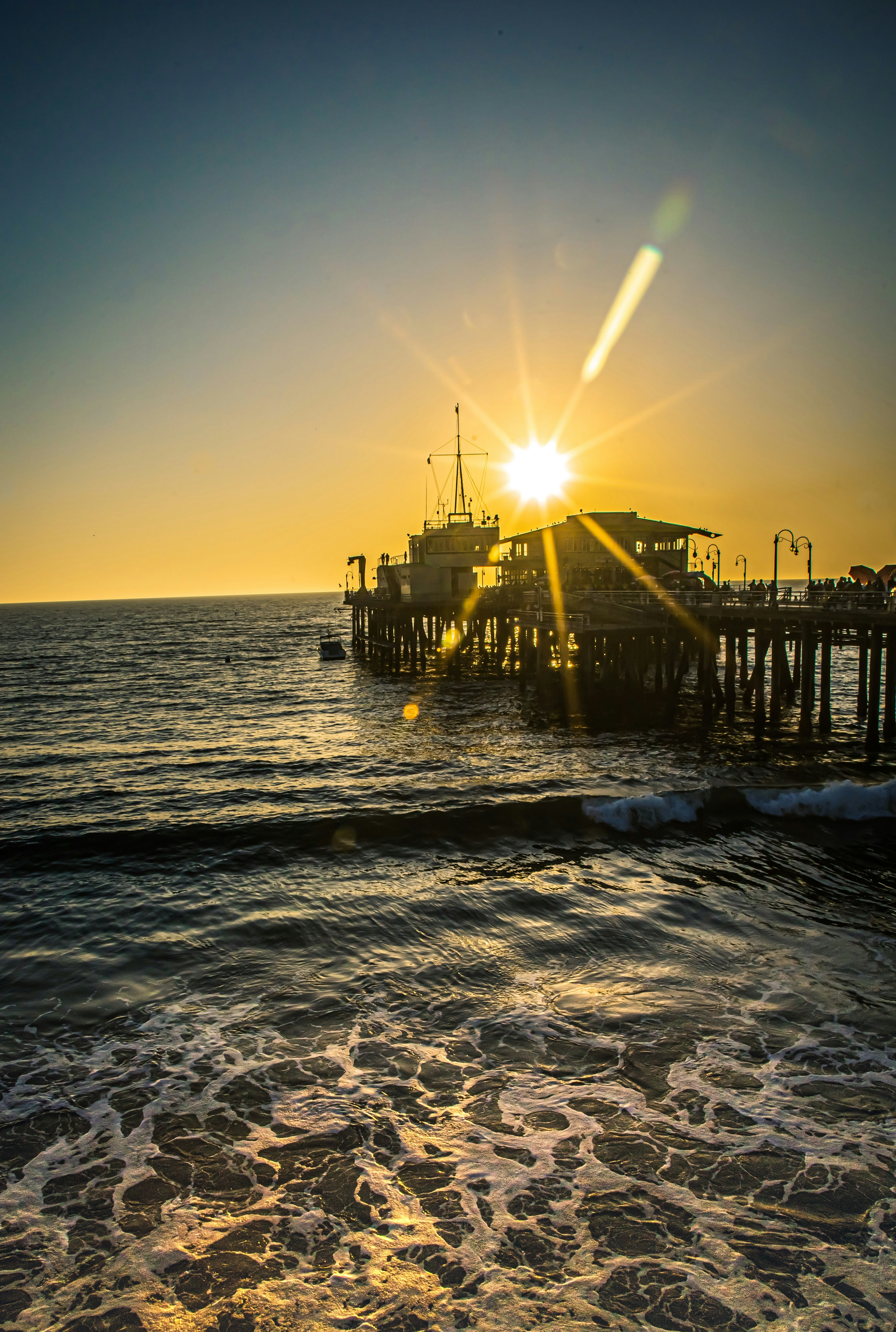 silhouette of dock on sea during sunset