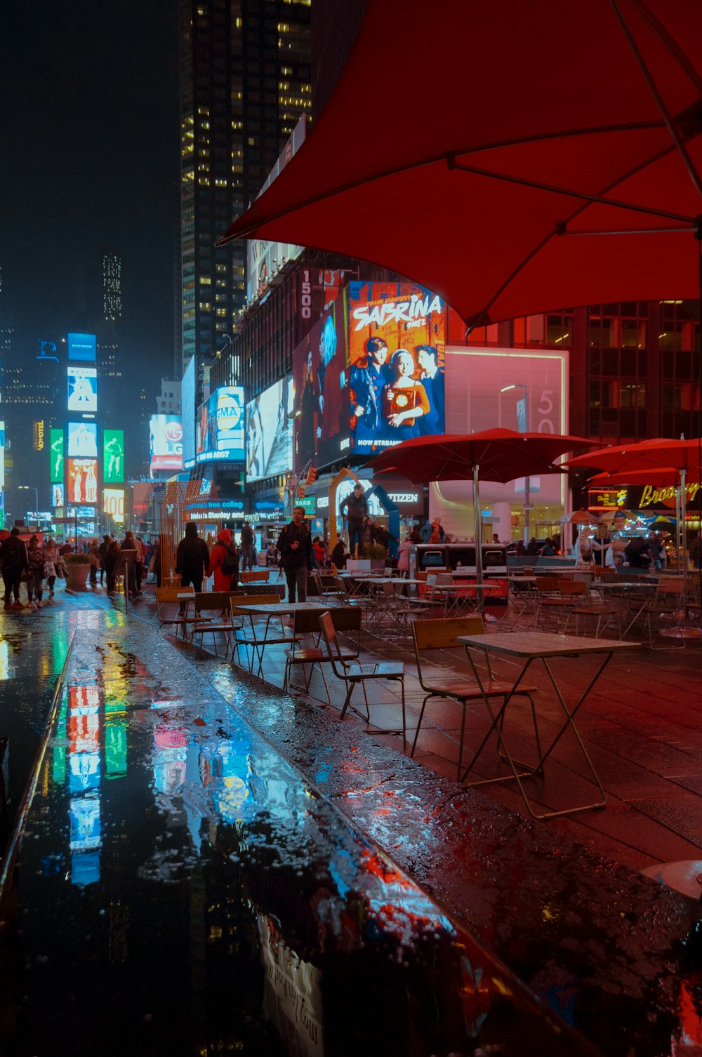people sitting on chair under red umbrella during night time
