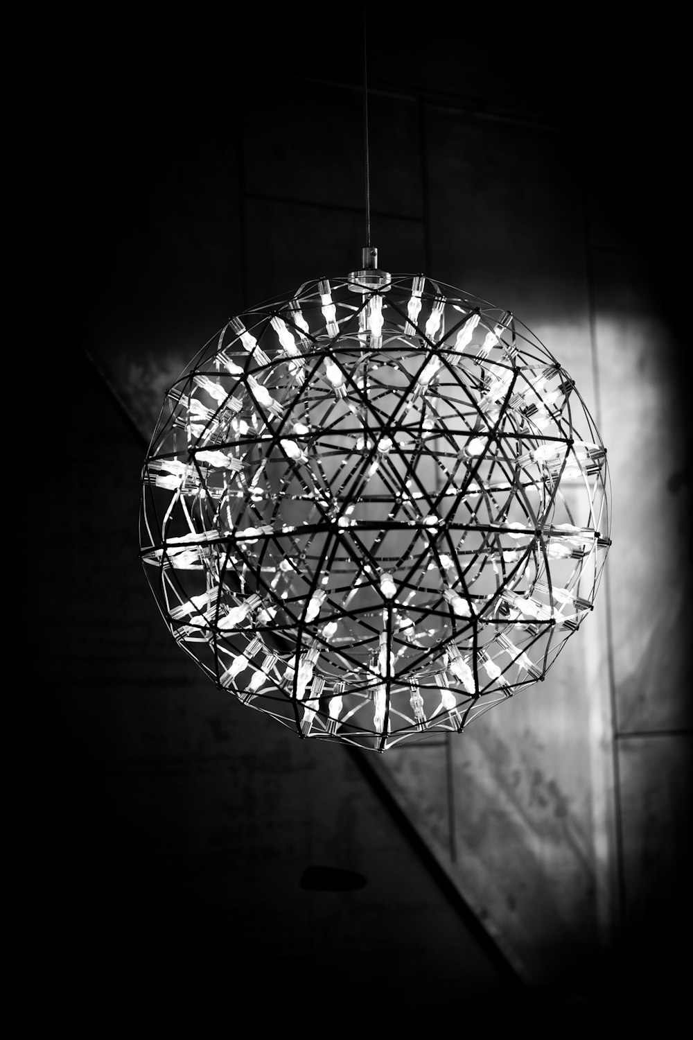 grayscale photo of round glass pendant lamp