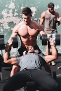 Personal trainer guiding a member through a bodybuilding workout.