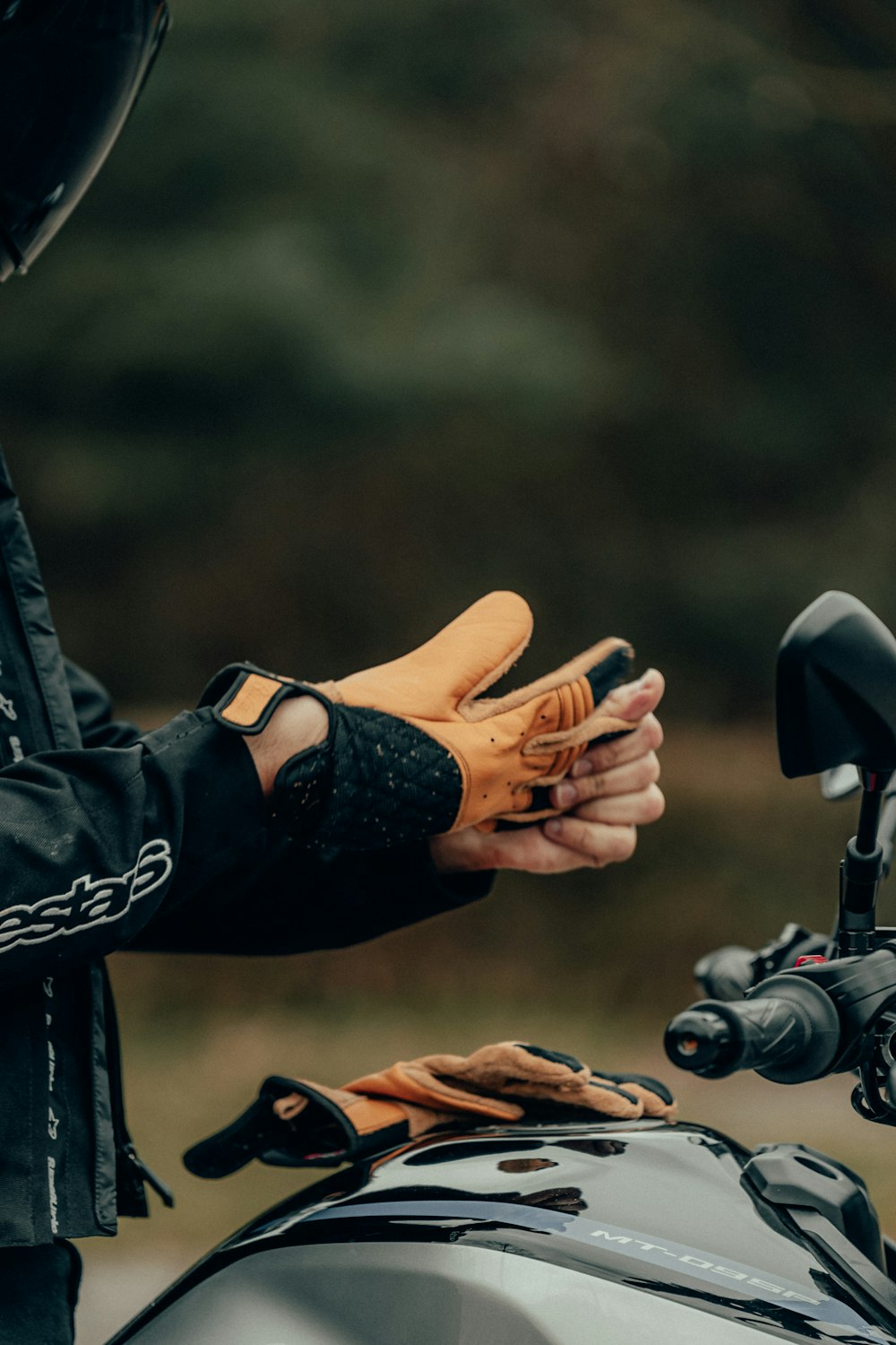 person in black leather jacket holding black and gray bicycle handle bar