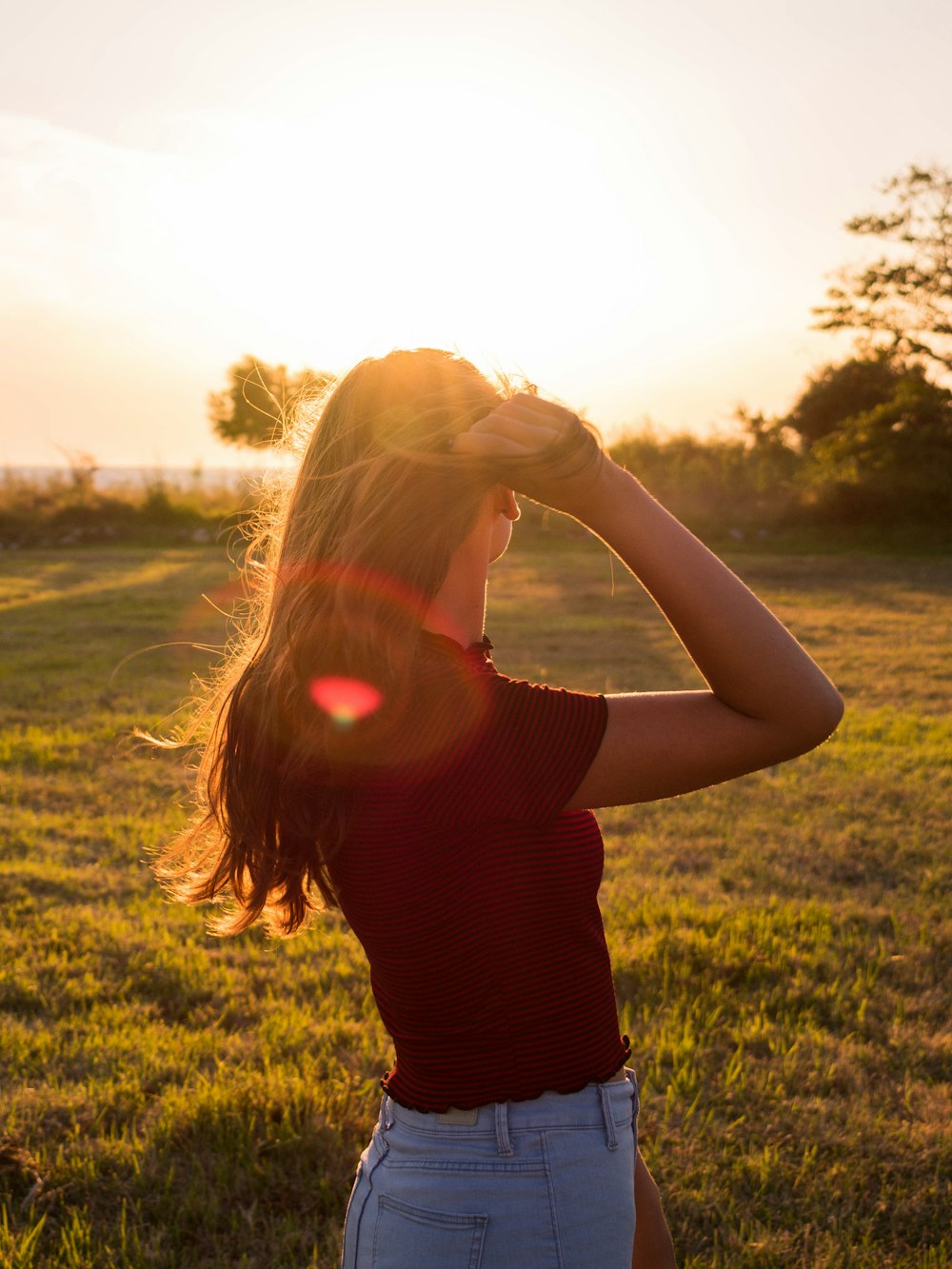 woman in black tank top covering her face with her hands