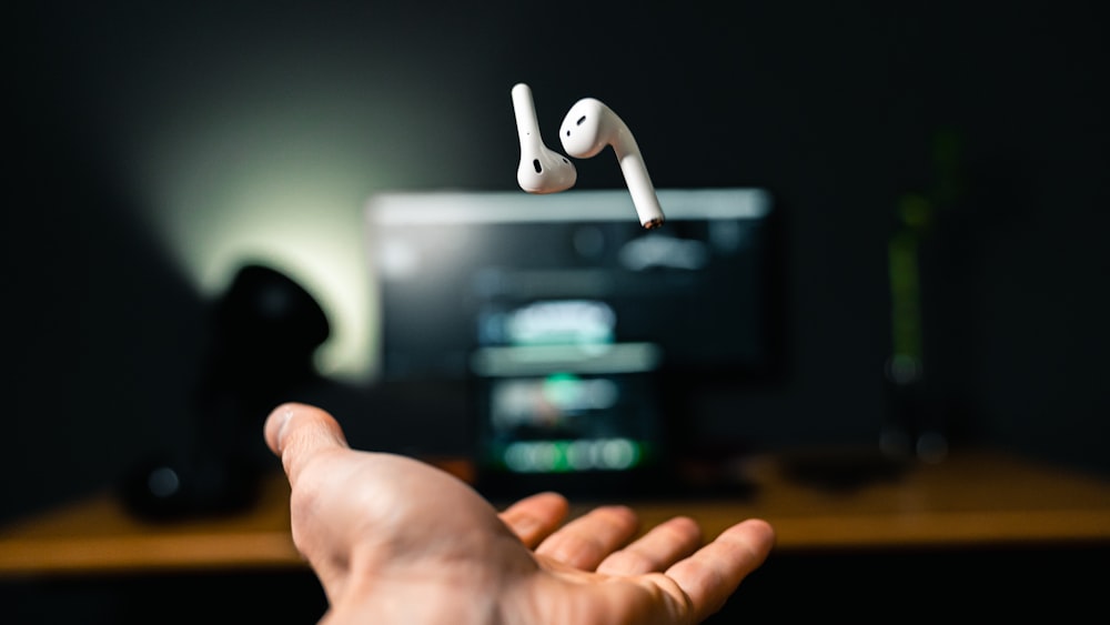 person holding white apple earpods