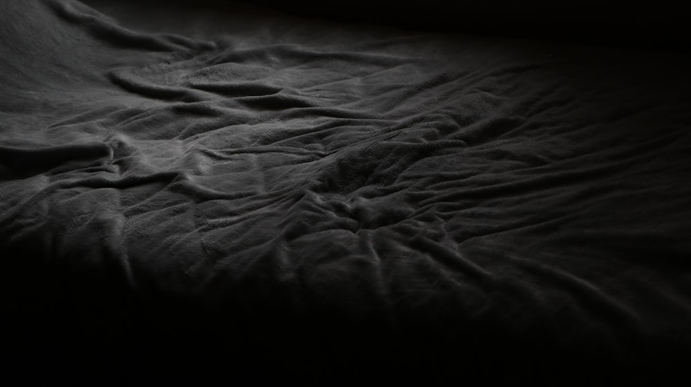 a black and white photo of an unmade bed