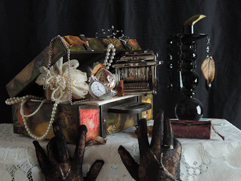 Hands gently sorting through family heirlooms and keepsakes on a wooden table.
