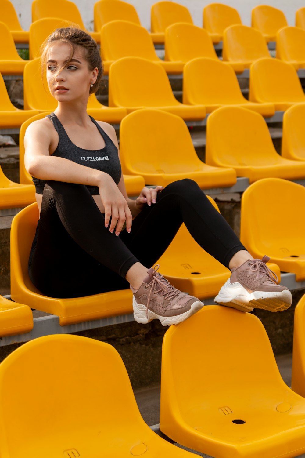 Sportive woman wearing black leggings and top sitting on chair Stock Photo