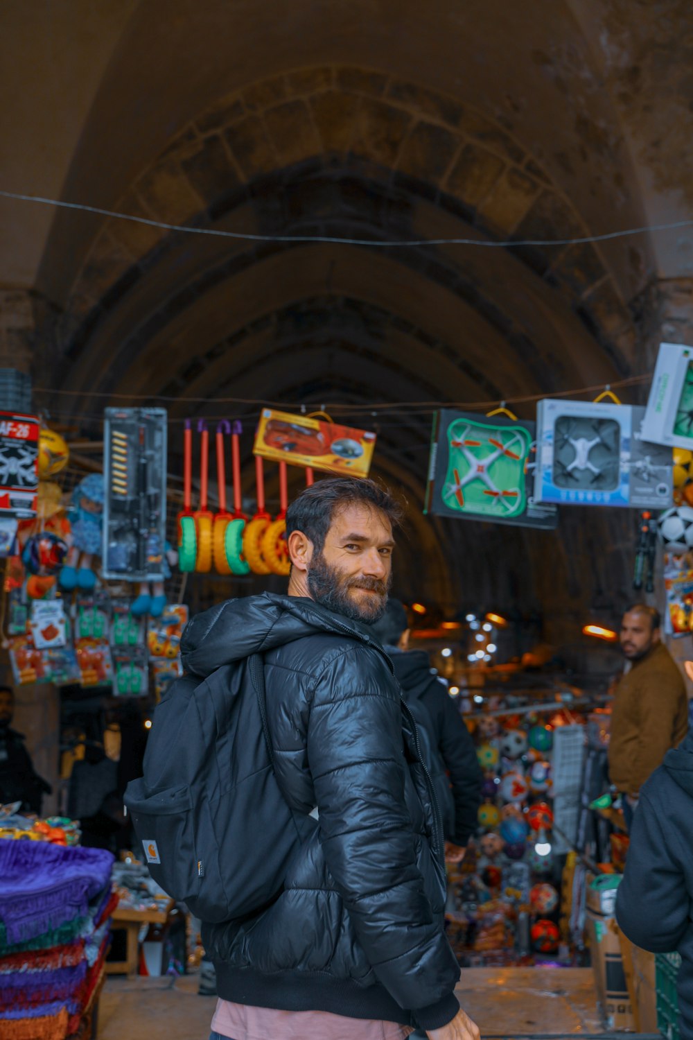 man in black leather jacket standing near store