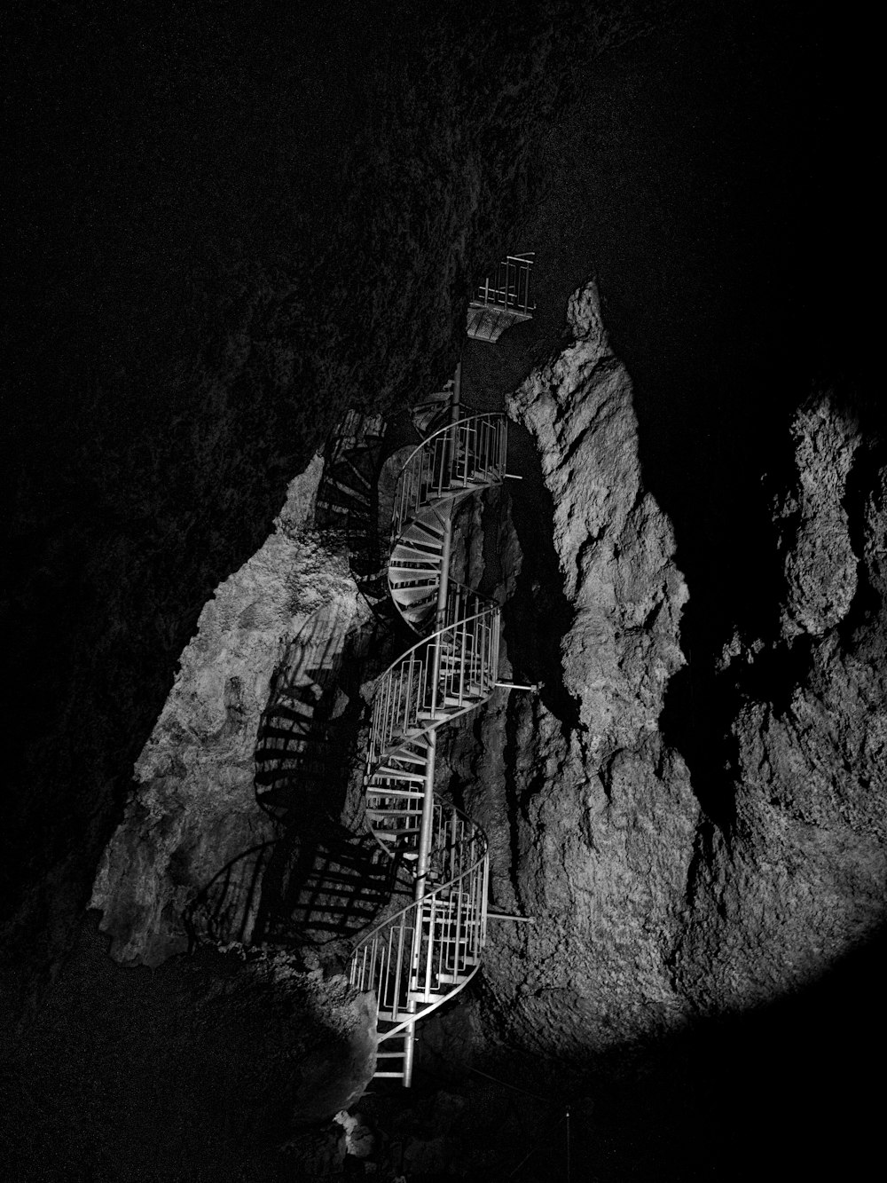 grayscale photo of spiral stairs