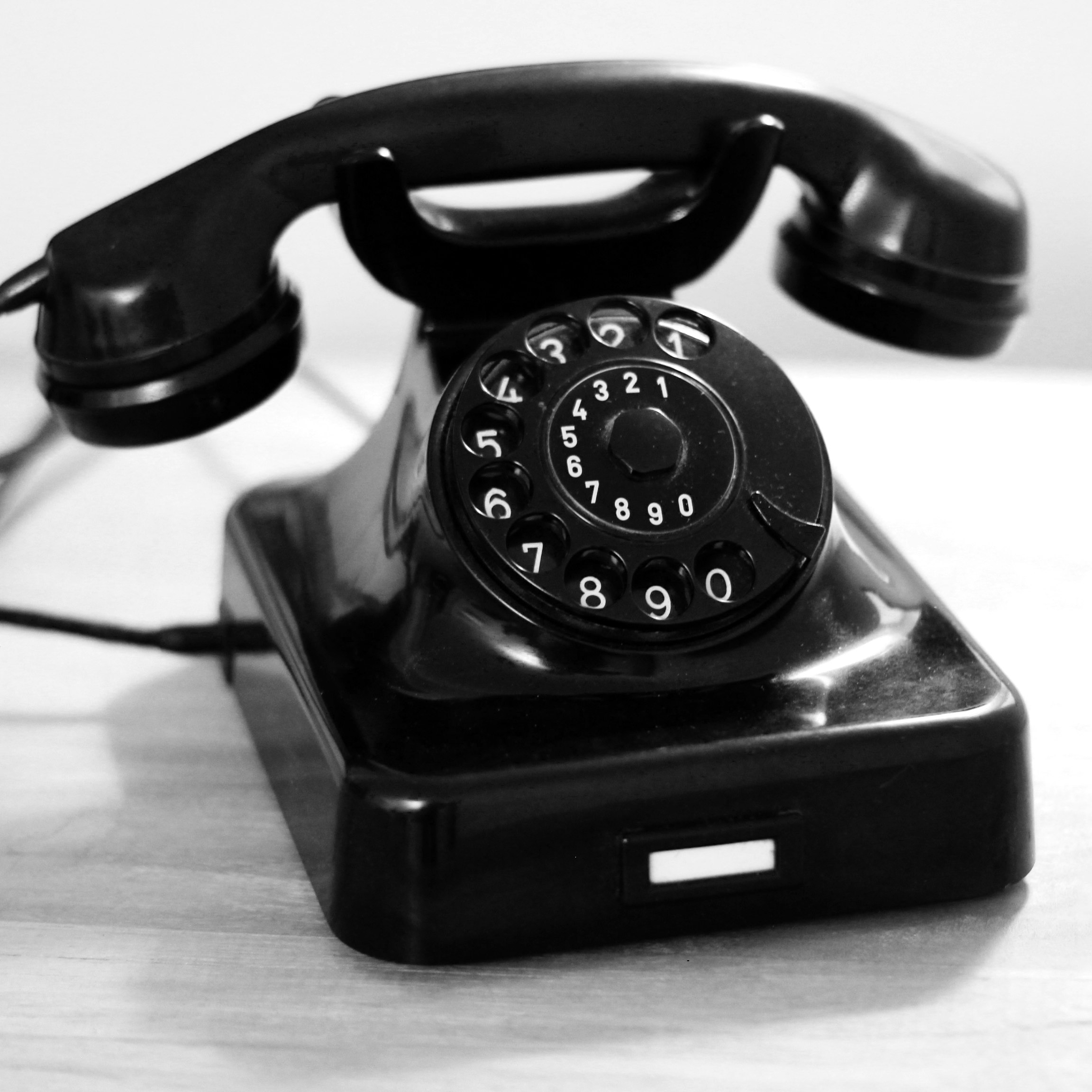 black rotary phone on white table