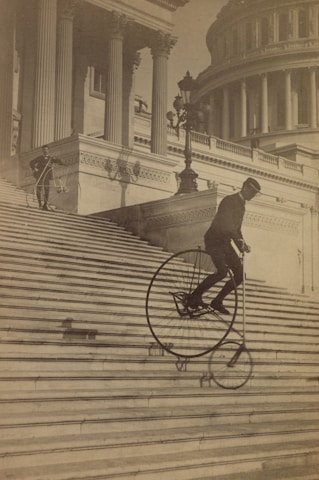 Man riding a bicycle down the steps of the U.S. Capitol