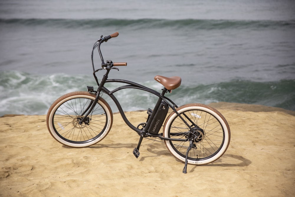 Bicicleta negra de cercanías en la orilla del mar durante el día
