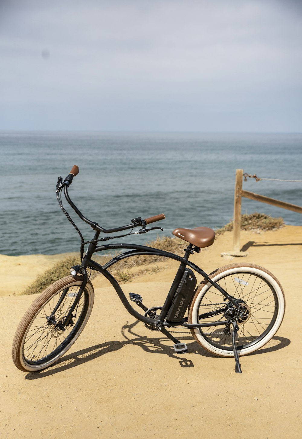 black city bike on beach during daytime