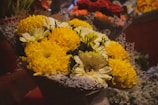 A cheerful mix of yellow daisies and orange marigolds wrapped in colorful paper.