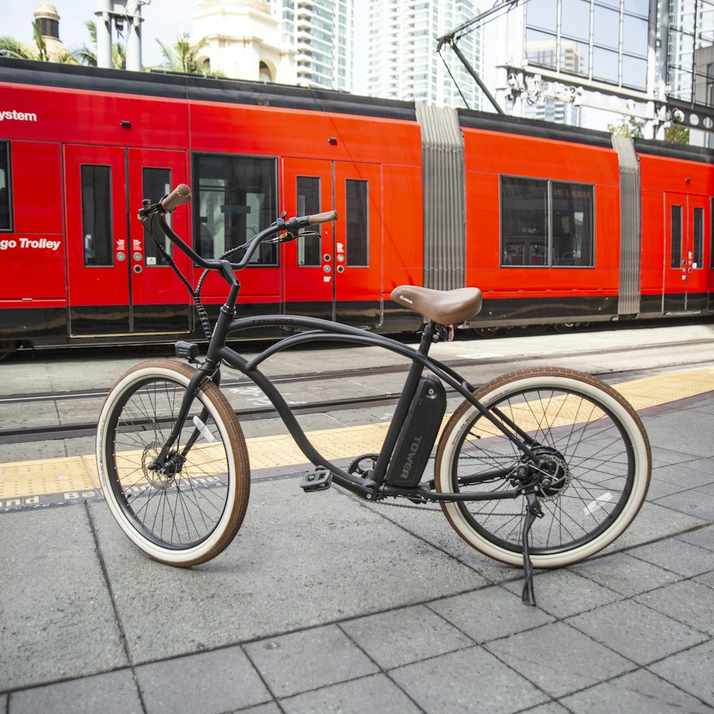 black city bike parked beside red and white building during daytime