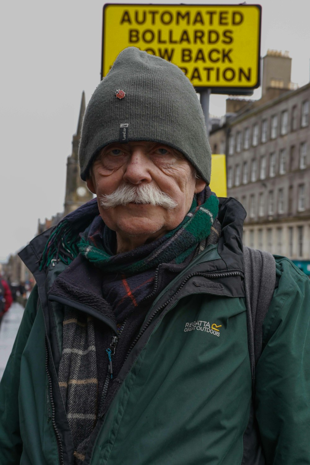 a man with a mustache and a green jacket