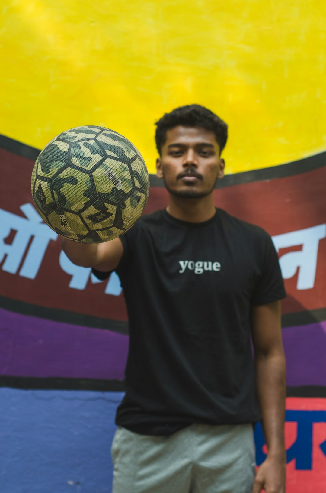 man in black crew neck t-shirt holding soccer ball