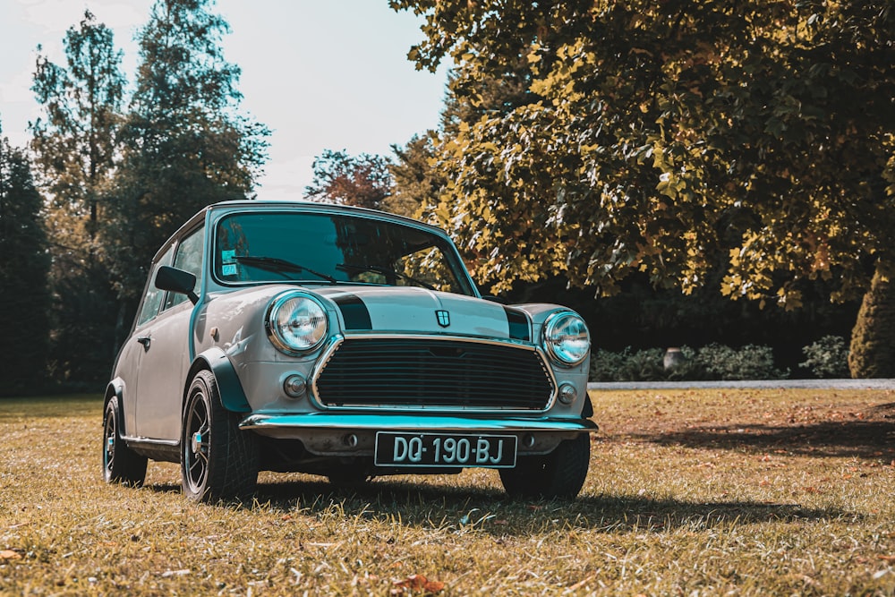 teal classic car on brown field during daytime