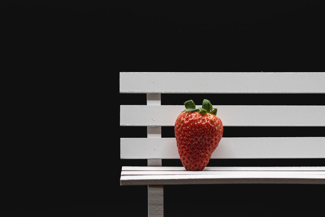 red strawberries on brown wooden bench