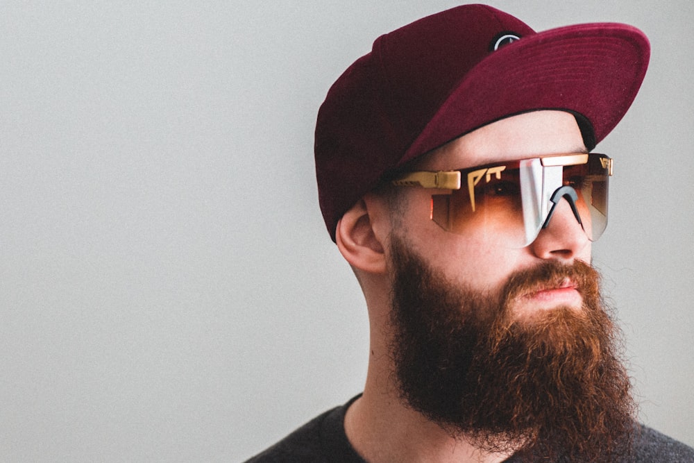 man in black crew neck shirt wearing black sunglasses and red cap