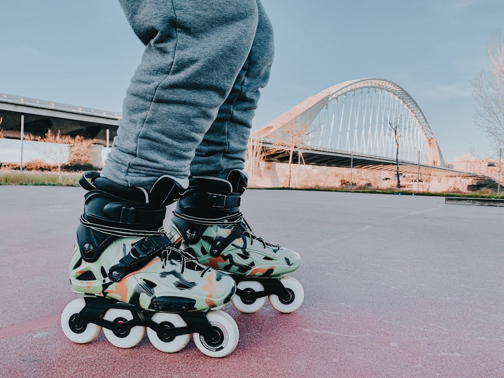 person in blue denim jeans and black and white sneakers riding on black and red skateboard