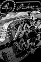 An intricate assembly of metallic gears and mechanical components with detailed reflections on a glossy surface. The scene includes circular cogs and patterns, suggesting a focus on machinery or a mechanical design project.